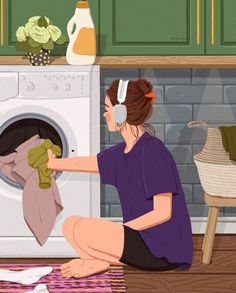 a woman is sitting on the floor in front of an oven and washing her clothes