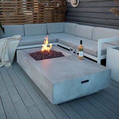 a fire pit sitting on top of a wooden floor next to a couch and table