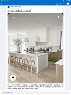 a white kitchen with lots of counter space and stools next to an island in the middle