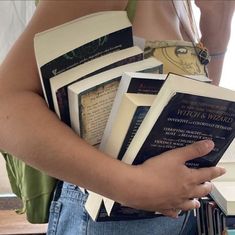 a person holding several books in their hands