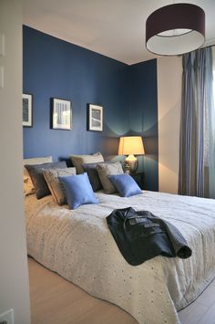 a bedroom with blue walls and white bedding