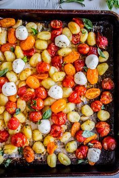 a pan filled with lots of different types of veggies on top of a table