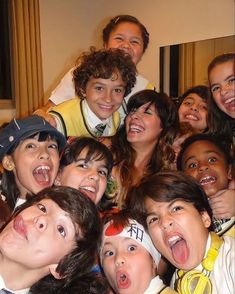 a group of young people posing for a photo together in front of a mirror with their mouths open