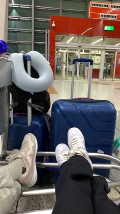 two people sitting on luggage carts with their feet propped up against the handlebars