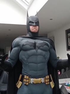 a man dressed as batman standing in a living room