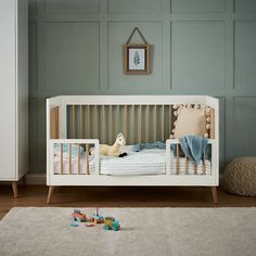 a baby's room with a crib and toys on the floor