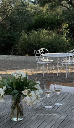 the table is set with white flowers and wine glasses