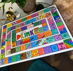 a board game is displayed on a table with a teddy bear and potted plant