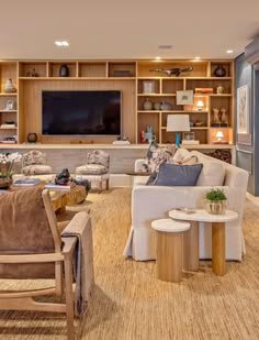 a living room filled with lots of furniture and a flat screen tv mounted on the wall