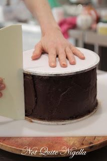 a person is holding the edge of a chocolate cake