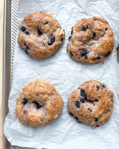 four blueberry bagels on a baking sheet ready to be baked in the oven