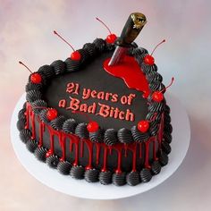 a black cake with red icing and a knife sticking out of it's center