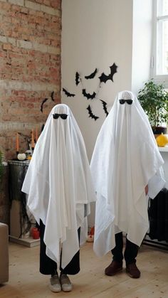 two people dressed in white cloths with bats on them