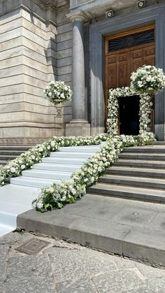 the steps are decorated with white flowers and greenery