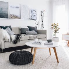 a living room filled with furniture and pictures on the wall above it's coffee table