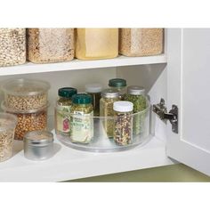 an organized pantry with jars, containers and cereals on the shelves in white cabinets