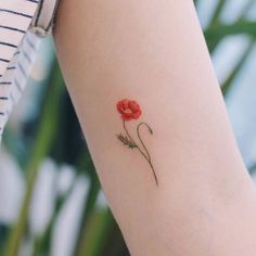 a single flower tattoo on the left arm