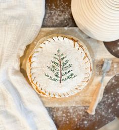 a pie with a tree painted on it is sitting on a table next to plates