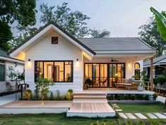 a small white house sitting on top of a lush green field