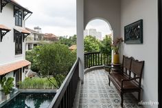 a bench sitting on top of a balcony next to a swimming pool in front of a building