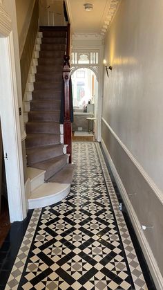 a hallway with stairs and tiled flooring