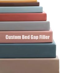 there is a stack of books with the words custom bed gap filler on them