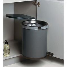 a stainless steel trash can in the corner of a cabinet