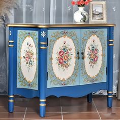 a blue cabinet with flowers painted on it