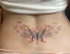 a woman's stomach with a butterfly tattoo on the side and stars around it