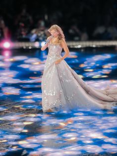 a woman in a white dress standing on a stage with bubbles all over her body