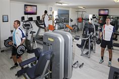 people in a gym with machines and treadmills