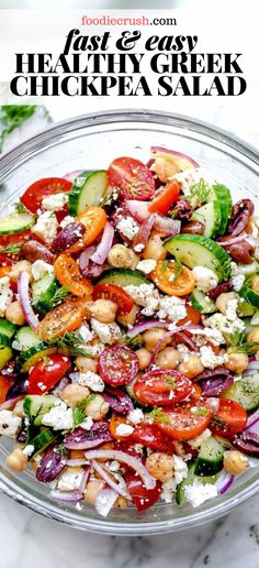 a salad with cucumbers, tomatoes, onions and feta cheese in a glass bowl