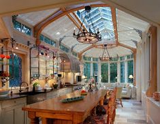 a kitchen with an island in the middle and lots of windows on the ceiling above it