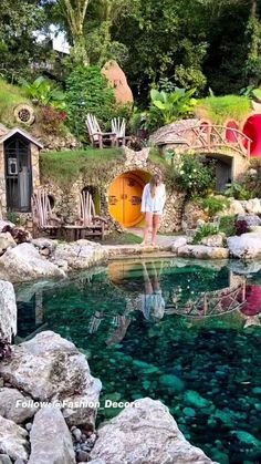 a woman standing in the middle of a pool surrounded by rocks and water features colorful doors