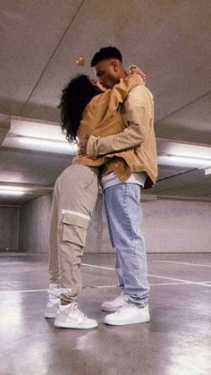 a man and woman embracing each other in an empty room