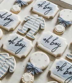 some decorated cookies are in a box with writing on the top, and one cookie has an image of a baby's boot