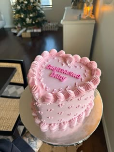 a pink heart shaped cake sitting on top of a table