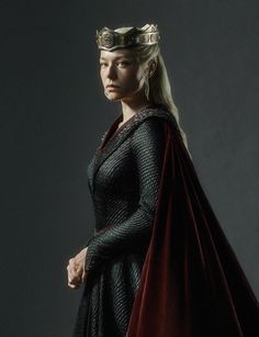 a woman in a costume with a crown on her head and cape over her shoulders