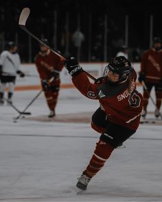 a hockey player is about to kick the puck in front of other players on an ice rink