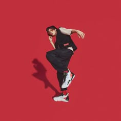 a man is jumping in the air on a red background