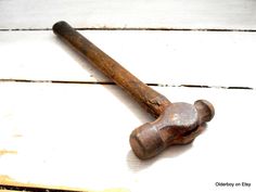 an old rusty hammer sitting on top of a white wooden floor