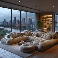 a living room filled with lots of furniture next to large windows overlooking a cityscape