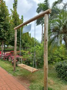 a wooden swing in the middle of a garden