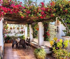 an outdoor dining area with potted plants and flowers