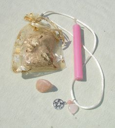 a pink pen and some rocks on a white tablecloth with a bag in the background