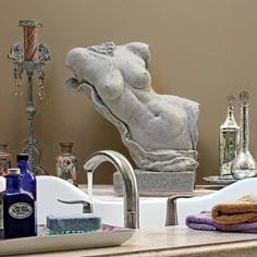 a bathroom sink with towels, soap and bottles on the counter top next to it