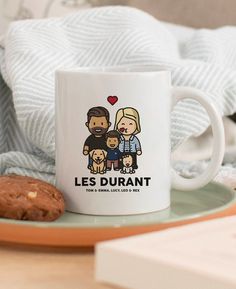 a coffee mug with the words les durantt on it next to a cookie