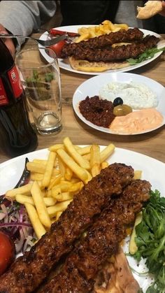 three plates with different types of food on them, one has fries and the other has salad