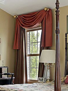 a bedroom with four poster bed and red curtains