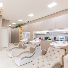 the interior of a hair salon with chairs and sinks